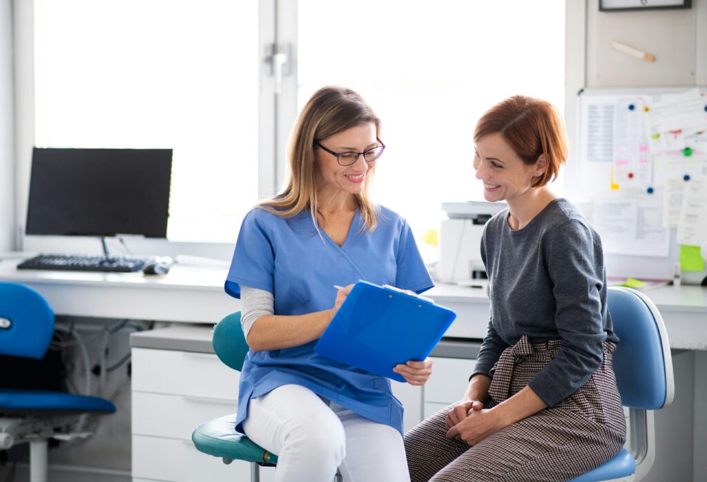 Healthcare professional reviewing documents with a patient in a medical clinic, creating a supportive and professional consultation environment.
